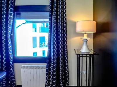 a lamp on a table next to a window at Flamingo Apartment by Hello Homes Sitges in Sitges