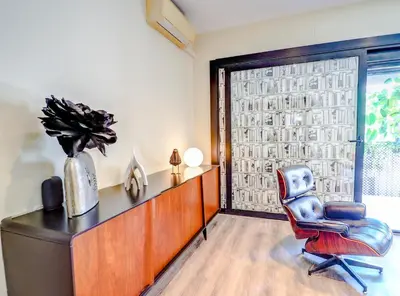 a living room with a chair and a window at Flamingo Apartment by Hello Homes Sitges in Sitges