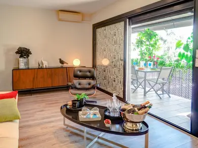 a living room with a chair and a table at Flamingo Apartment by Hello Homes Sitges in Sitges