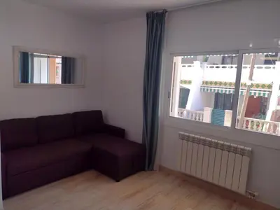 a living room with a couch and a window at Mar & Cunit in Cunit