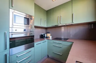 a kitchen with green cabinets and a stove top oven at Sweett - Casa Palau in Barcelona