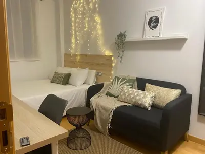 a small living room with a bed and a couch at El Capricho Terrassa. in Terrassa