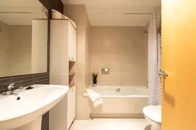 a bathroom with a sink and a tub and a toilet at El Capricho Terrassa. in Terrassa