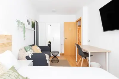 a living room with a couch and a table at El Capricho Terrassa. in Terrassa