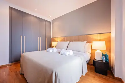 a bedroom with a large white bed with two towels at Sweett - Jardinets in Barcelona
