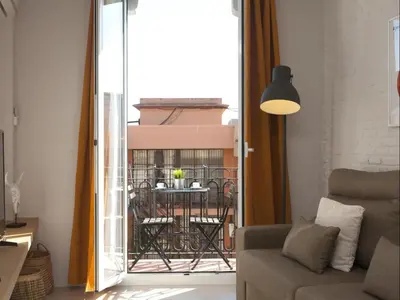 a living room with a view of a balcony at Sunny Playa Apartment in Barcelona
