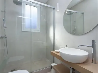 a white bathroom with a sink and a shower at Sunny Playa Apartment in Barcelona