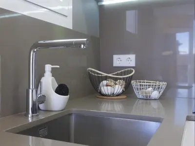 a kitchen sink with a faucet and two baskets at Sunny Playa Apartment in Barcelona