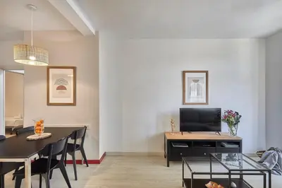 a living room with a dining table and a television at BBarcelona Modern Eixample Flat in Barcelona