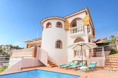 a villa with a swimming pool in front of a house at Charming Spanish Villa private pool / Sea views in Sitges