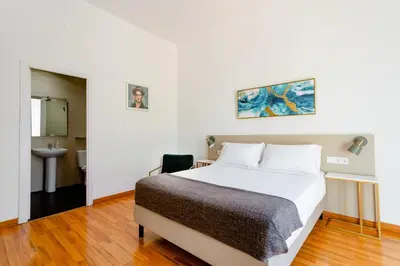 a bedroom with a large bed and a bathroom at Casa Lolita in Barcelona