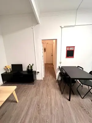 a room with a table and chairs and a white wall at Poble Sec. Excelente ubicación cerca de la playa y de las Ramblas in Barcelona