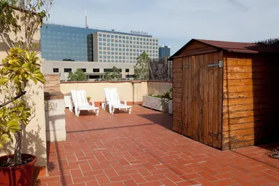 a small wooden building with two white chairs on a patio at Penthouse Vallespir in Barcelona