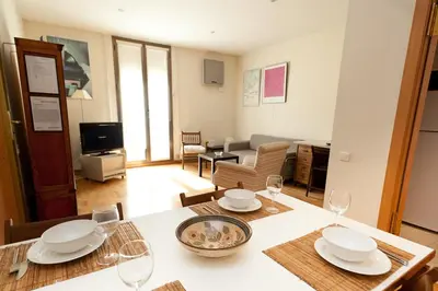 a kitchen and living room with a table with wine glasses at Penthouse Vallespir in Barcelona