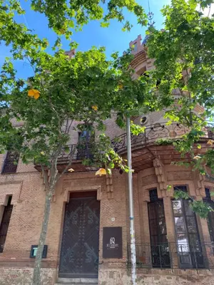 a building with a tree in front of it at Luminoso apartamento en Canet de Mar cercano a la playa y a Barcelona in Canet de Mar