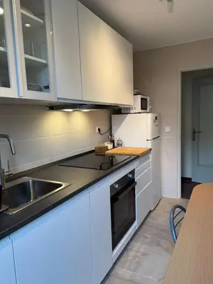 a kitchen with white cabinets and a sink at Luminoso apartamento en Canet de Mar cercano a la playa y a Barcelona in Canet de Mar