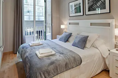 a bedroom with a large bed with two towels on it at Habitat Apartments Batlló in Barcelona