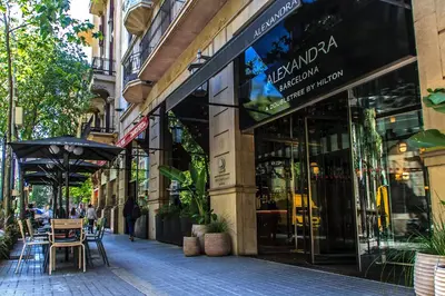 a store front of a street with tables and an umbrella at Habitat Apartments Batlló in Barcelona