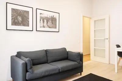 a living room with a couch and two pictures on the wall at Habitat Apartments Batlló in Barcelona