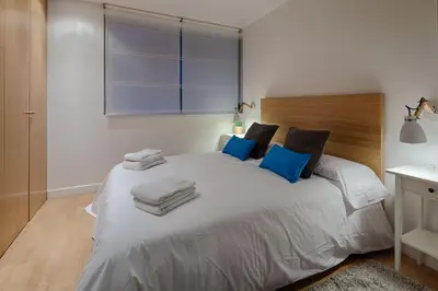 a bedroom with a large white bed with blue pillows at Habitat Apartments Pedrera in Barcelona