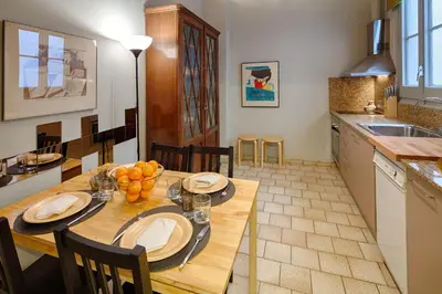 a kitchen and dining room with a wooden table at Habitat apartments Barcelona Center in Barcelona