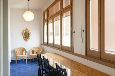 a dining room with a table and chairs and windows at Habitat apartments Barcelona Center in Barcelona