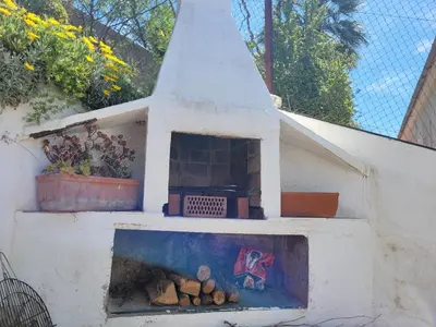 an outdoor oven with logs inside of it at Cal Jamila in Cubelles