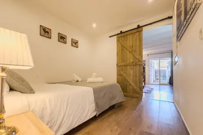 a bedroom with two beds and a sliding door at Cozy Place next to Park Güell in Barcelona