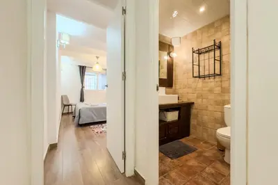 a bathroom with a toilet and a bed in a room at Cozy Place next to Park Güell in Barcelona