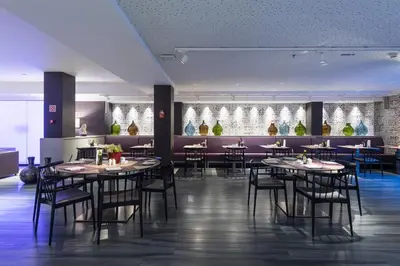 a bar with black stools in a room at Catalonia Square 4* Sup in Barcelona