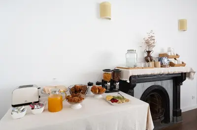 a table with breakfast foods and orange juice on it at Divino Hotel Boutique in Sitges