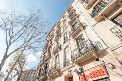 a large building with balconies and a sign on it at True Design in Heart of Noble BCN in Barcelona