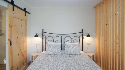 a bedroom with a large bed with a metal headboard at Holidays en Arenys de Mar y Montaña in Arenys de Mar