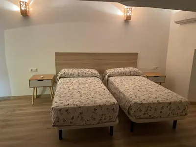 two beds in a room with two tables at Masia Can Llonch in Palau-Solità i Plegamans