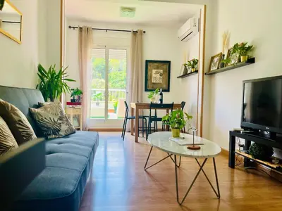 a living room with a blue couch and a table at Attic360Views in Barcelona