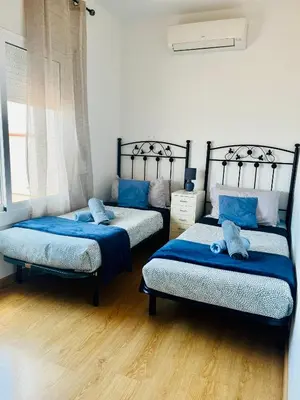 a bedroom with two beds with blue sheets at Attic360Views in Barcelona