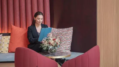 a woman sitting at a table with a glass of wine at ARCELON HOTEL - From 2023 in Barcelona