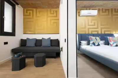 a couch with pillows and a vase with a plant at The Collection Barcelona - Amazing 3 Bedroom Apartment with indoor POOL in Barcelona