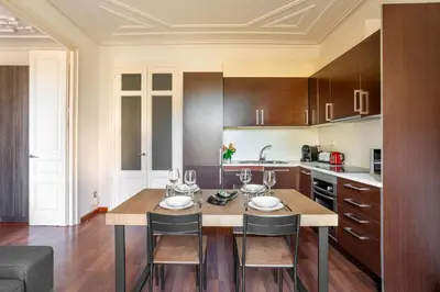 a kitchen with a wooden table and chairs in a room at The Collection Barcelona - Plaza Urquinaona Cozy and comfortable in Barcelona