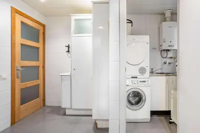 a white laundry room with a washer and dryer at The Collection Barcelona - Elegant 3-bedroom Apartment in the Heart of BCN in Barcelona