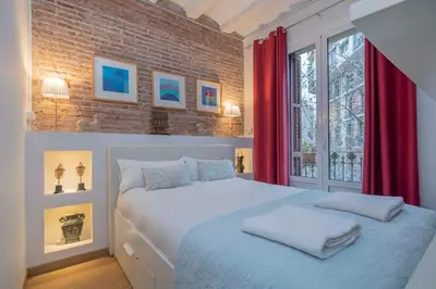 a bedroom with a large bed with red curtains at The Collection Barcelona - Exclusive 2 bedroom apartment in the city center in Barcelona