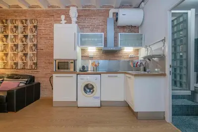 a kitchen with a washing machine and a washer at The Collection Barcelona - Exclusive 2 bedroom apartment in the city center in Barcelona