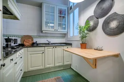 a kitchen with white cabinets and a wooden table at The Collection Barcelona - Elegant 4 bedrooms 3 bathrooms Catalan home in Barcelona