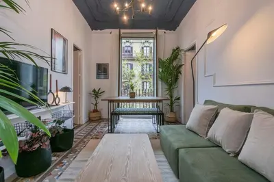 a living room with a green couch and a table at The Collection Barcelona - Elegant 4 bedrooms 3 bathrooms Catalan home in Barcelona