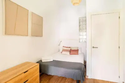 a white bathroom with a toilet and a window at The Collection Barcelona - Pl Universitat Bright and cozy 2BD - 2BTH in Barcelona