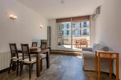 a wooden table and chairs on a balcony with a building at The Collection Barcelona -3BD with private terrace right by Sagrada Familia in Barcelona
