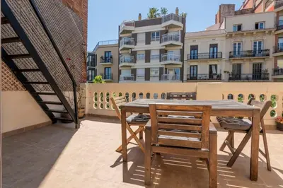 a wooden table and chairs on a balcony at The Collection Barcelona -3BD with private terrace right by Sagrada Familia in Barcelona