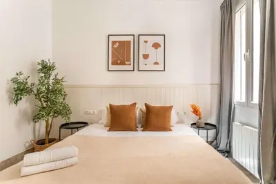 a bedroom with a large bed with two tables at The Collection Barcelona - Historic apartment with private terrace in Example in Barcelona