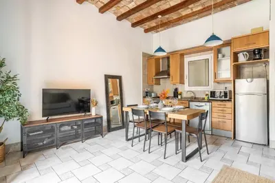 a kitchen and living room with a table and chairs at The Collection Barcelona - Historic apartment with private terrace in Example in Barcelona