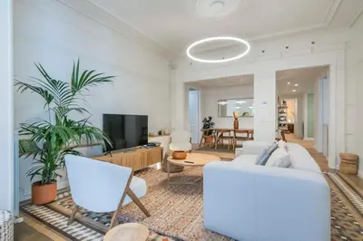a living room with a white couch and a tv at The Collection Barcelona - Exclusive Paseo de Gracia 5BD 5BTH with terrace in Barcelona